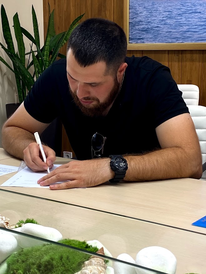 Yevgeniy Nikolov signs the final compensation agreement in the MTWTU office