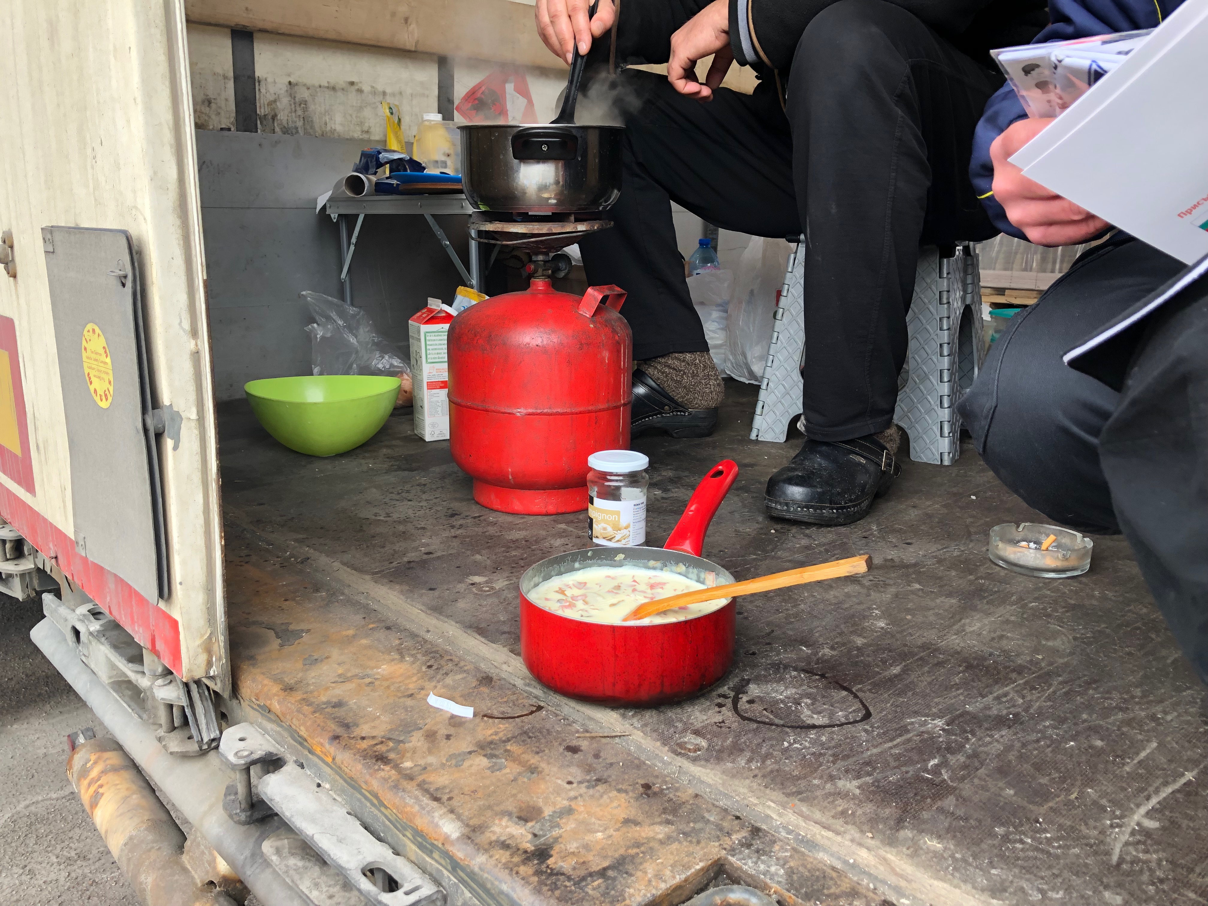 Truck drivers cook food in their trailer